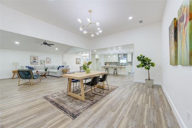 The dining room offers an elegant space for family gatherings and dinner parties. It overlooks the living room and provides access to the kitchen, offering easy flow for entertaining. The updated luxury vinyl flooring and fresh paint create a sleek, modern ambiance. | Image 4