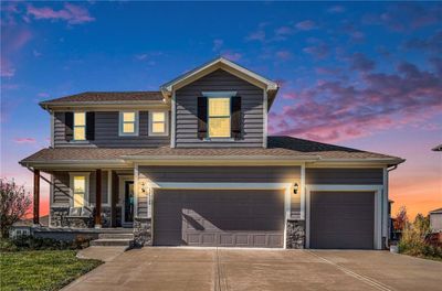 View of front facade with a garage and a porch | Image 1