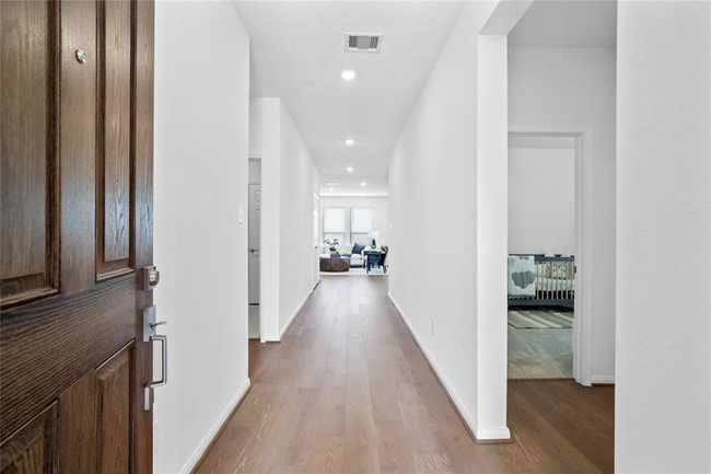 Welcome to your new home at 3524 Sage Green Trail. You are greeted with this beautiful entryway featuring gorgeous engineered wood flooring, recessed lighting and custom paint. | Image 4