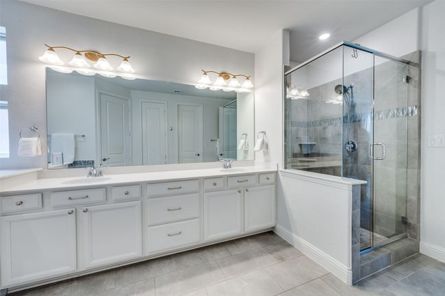 Glassed in shower and tile flooring with neutral colors make this space bright and airy. | Image 20