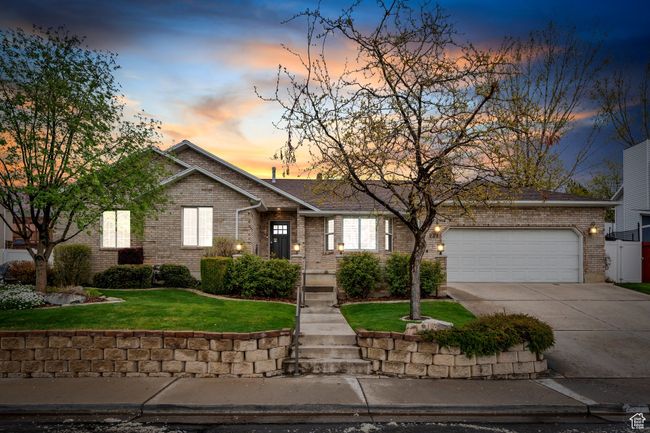View of front of home with concrete driveway, a front lawn, brick siding, and an attached garage | Image 46