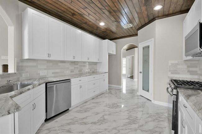 Kitchen with new appliances, granite counter tops, new sink and new garbage disposal. Pantry on the left. and dining room ahead | Image 14