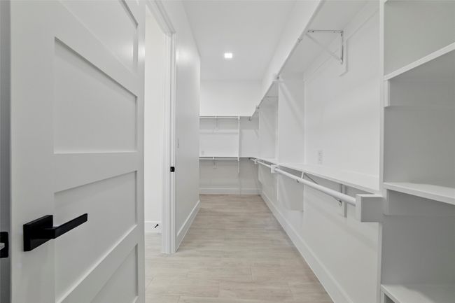 Walk in closet featuring light wood-style floors | Image 35