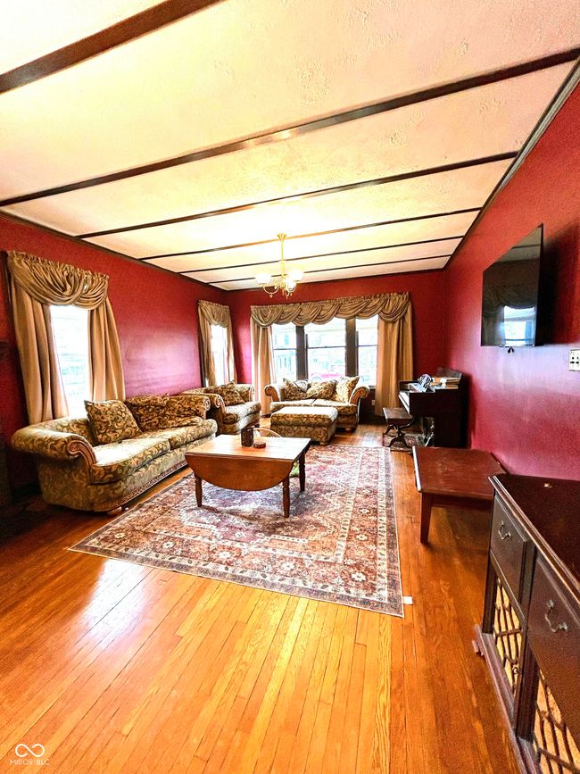 living area with beam ceiling, an inviting chandelier, and hardwood / wood-style floors | Image 9
