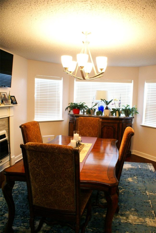 Dining room with a chandelier and wood finished floors | Image 10