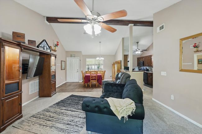 Living room with baseboards, a ceiling fan, beam ceiling, and visible vents | Image 10