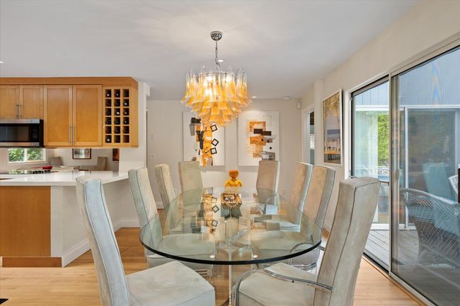 Dining room featuring light wood finished floors and a chandelier | Image 5