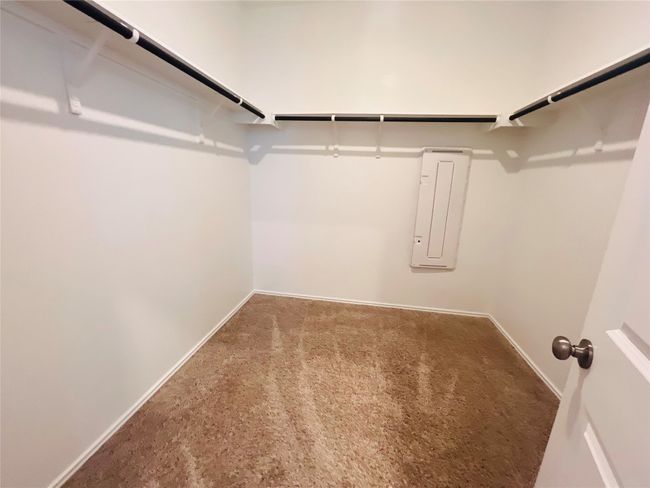 Spacious closet with carpet flooring and electric panel | Image 10