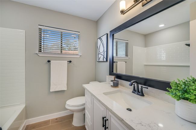 Bathroom featuring vanity, wood finished floors, and shower combination | Image 16