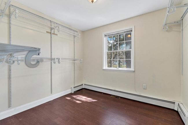 Walk in closet featuring hardwood / wood-style flooring, a wall mounted air conditioner, and a baseboard heating unit | Image 23