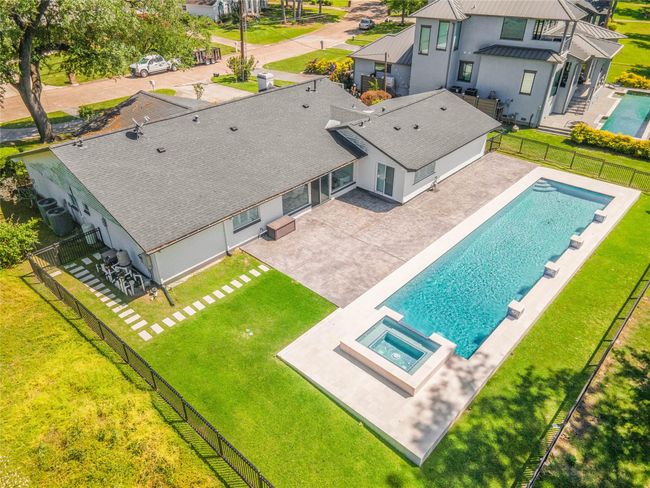 Aerial view of the resort-style backyard showcasing the 65-foot lap pool, spa, spacious patio, and fully fenced lawn—perfect for outdoor entertaining. | Image 28