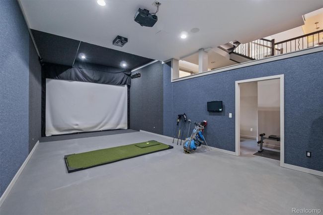Game room featuring golf simulator and a textured wall | Image 32