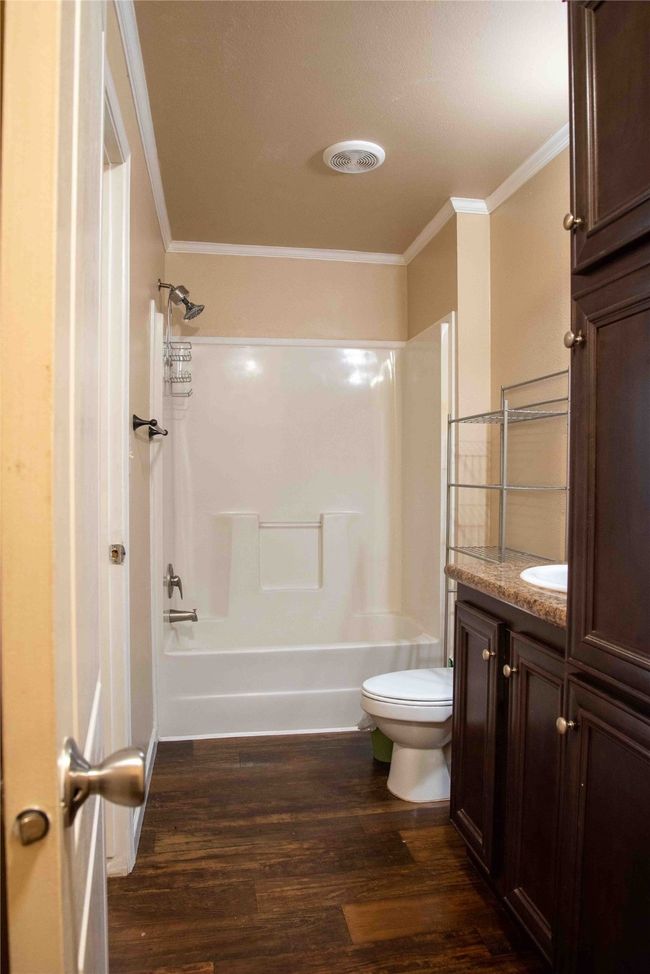 Master Bathroom featuring ornamental molding, shower combination, toilet, visible vents, and wood finished floors | Image 29