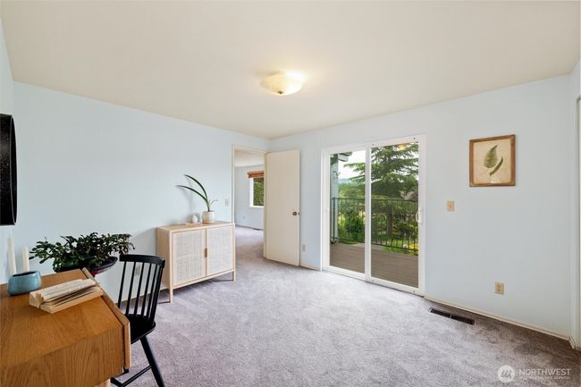The primary suite offers a peaceful retreat with its ensuite room and views of the surrounding nature and balcony access. | Image 22