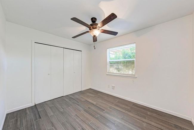 Unfurnished bedroom featuring a closet, baseboards, wood finished floors, and a ceiling fan | Image 24