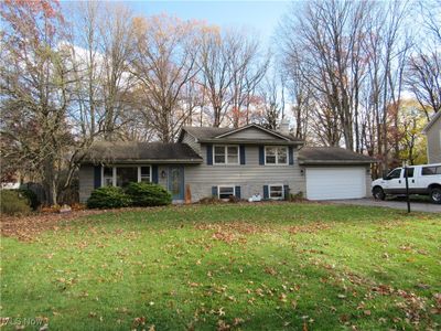 Split level home with a garage and a front lawn | Image 1