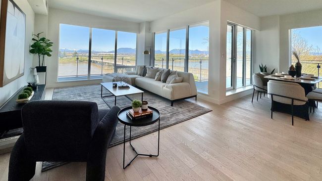Living area featuring a water and mountain view, light wood-style flooring, and a healthy amount of sunlight | Image 9