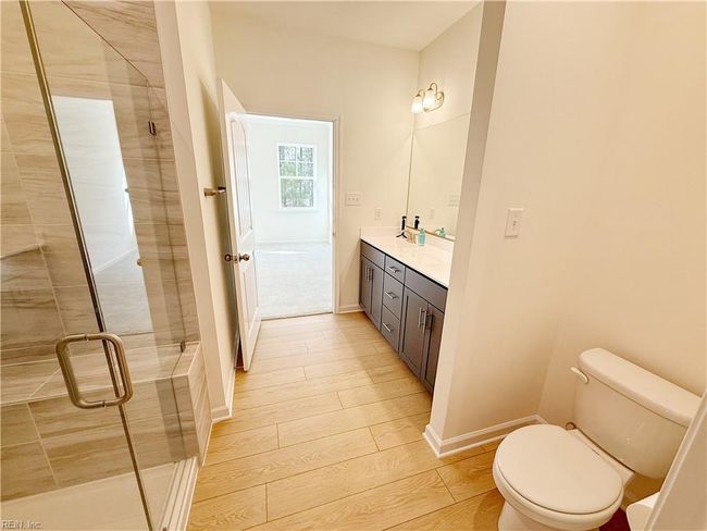 A first-floor primary suite features a walk-in closet and an ensuite bath with double vanity. | Image 9