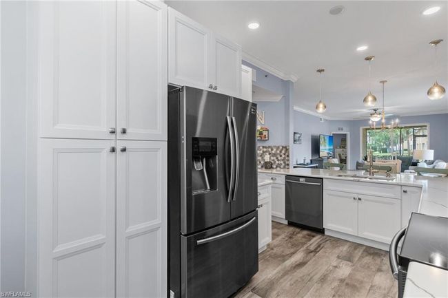 Kitchen featuring pendant lighting, sink, dishwasher, and stainless steel refrigerator with ice dispenser | Image 4
