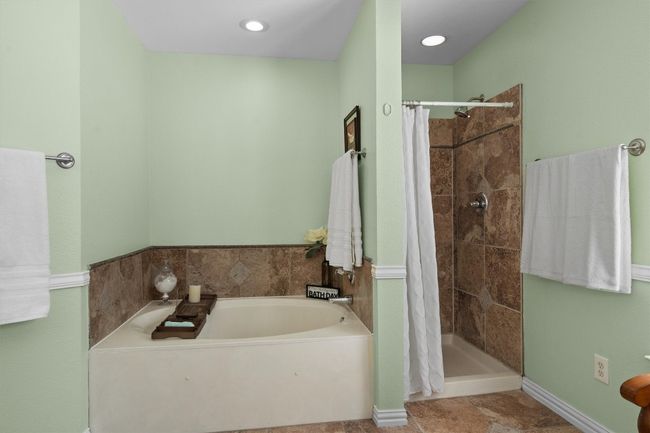 luxurious bath featuring double vanities, two walk-in closets, a garden tub, and a separate shower. | Image 28
