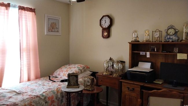 Bedroom featuring multiple windows and an office area | Image 12