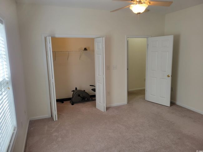 Unfurnished bedroom with carpet floors, a closet, and a ceiling fan | Image 27
