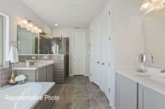 Bathroom featuring two vanities, a sink, a stall shower, visible vents, and a garden tub | Image 9