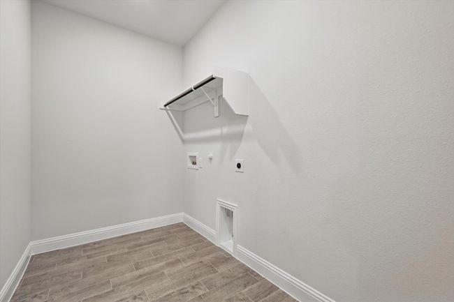 Washroom with hookup for a washing machine, electric dryer, laundry area, and tile floors that look like wood | Image 20