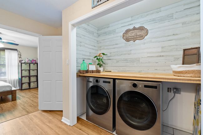 Laundry room with independent washer and dryer, wooden walls, light wood finished floors, and a ceiling fan | Image 16