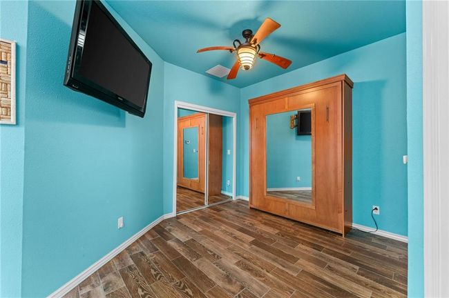 Unfurnished bedroom featuring dark wood-style flooring, ceiling fan, a closet, and baseboards | Image 51