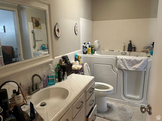 Full bathroom with a bath, vanity, toilet, and tasteful backsplash | Image 15