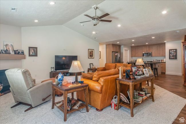 Living area with recessed lighting, a ceiling fan, vaulted ceiling, wood finished floors, and baseboards | Image 11