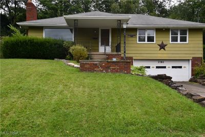 View of front facade with a garage and a front yard | Image 1