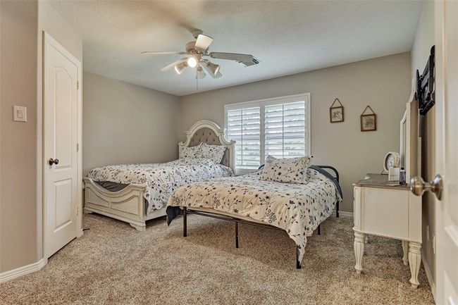 Expansive upstairs second bedroom with elegant plantation shutters. | Image 17