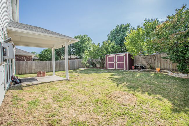 View of yard with a fenced backyard, an outbuilding, a storage shed, and a patio | Image 25