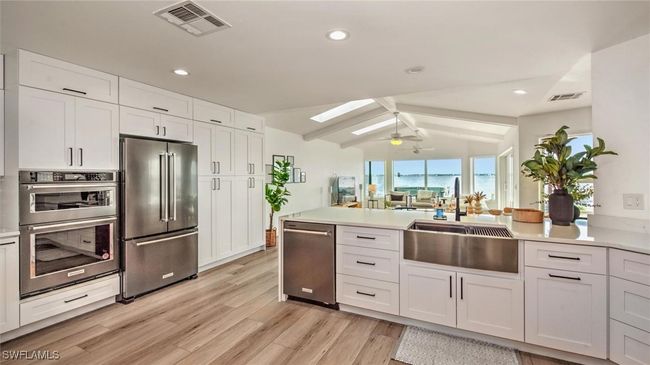 Kitchen featuring appliances with stainless steel finishes, light wood-style floors, a peninsula, light countertops, and recessed lighting | Image 14
