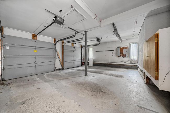 Garage featuring electric panel and a garage door opener | Image 33