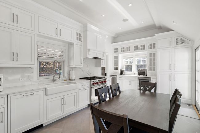 Kitchen with designer range, decorative backsplash, sink, and white cabinets | Image 23