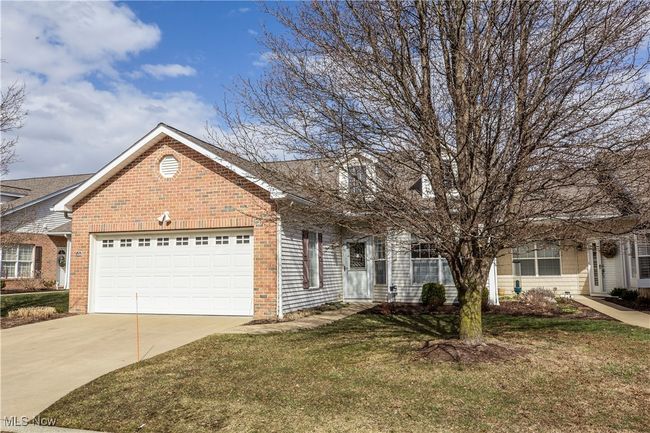 View of front of house with an attached garage, a front lawn, concrete driveway, and brick siding | Image 33