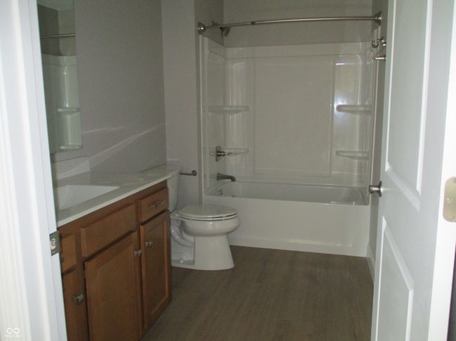 full bath with vanity, washtub / shower combination, toilet, and wood finished floors | Image 14