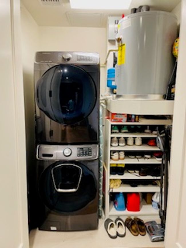 Laundry area with stacked washer / drying machine and water heater | Image 6