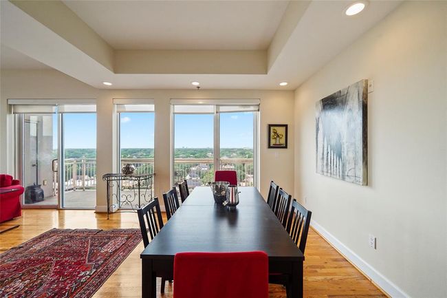 Elegant dining area with breathtaking views, featuring abundant natural light and a seamless flow to the outdoor balcony. Perfect for entertaining. | Image 11