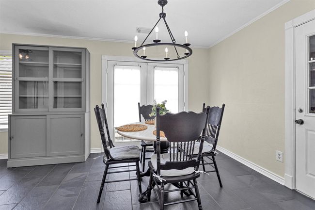 Enjoy sunny mornings in the inviting breakfast room, where French doors open to a private side yard and spacious deck—perfect for seamless indoor-outdoor living. Filled with natural light, this cozy dining space offers a relaxed setting for everyday meals and casual entertaining. | Image 9