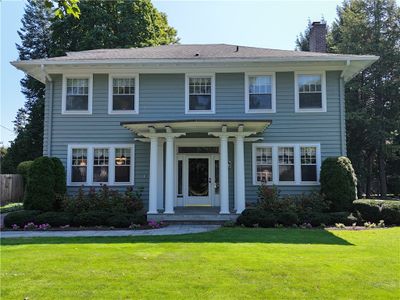 This Palladian Colonial stands as a testament to timeless design, wrapped in a living tapestry of vibrant perennial gardens and meticulously manicured grounds. | Image 1