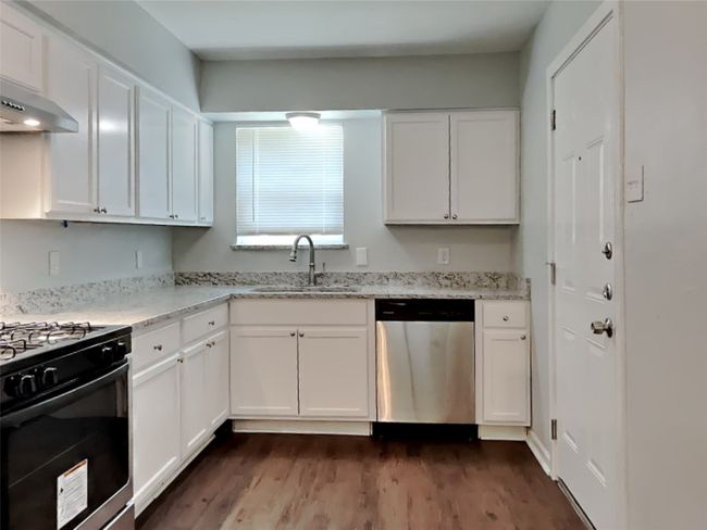 Kitchen with dishwasher, range with gas cooktop, and white cabinetry | Image 4