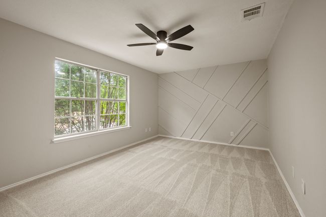 All of the bedrooms are spacious with large windows, fresh carpet, and modern ceiling fans. | Image 29