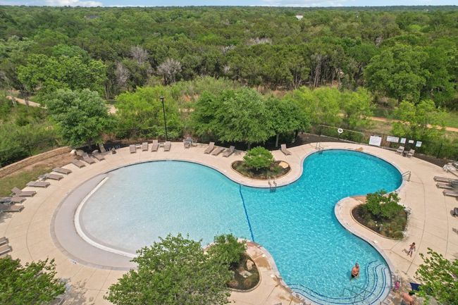 Community pool featuring fence, a patio area, and a view of trees | Image 35
