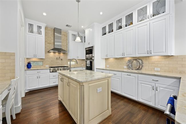 Kitchen with Thermador stainless steel appliances, wall chimney range hood, a sink, dark wood-style flooring, and recessed lighting | Image 7