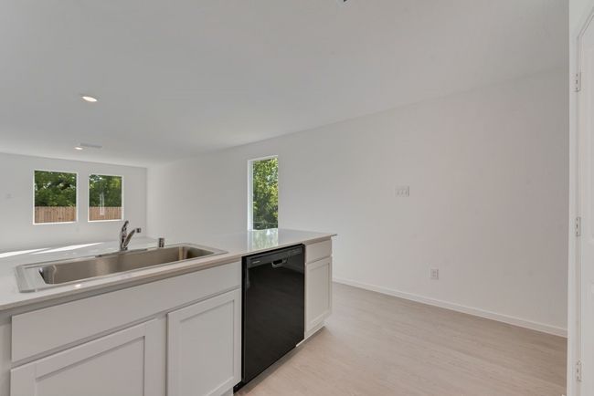 Kitchen featuring white cabinetry, dishwasher, light wood-style flooring, recessed lighting, and light stone countertops | Image 11