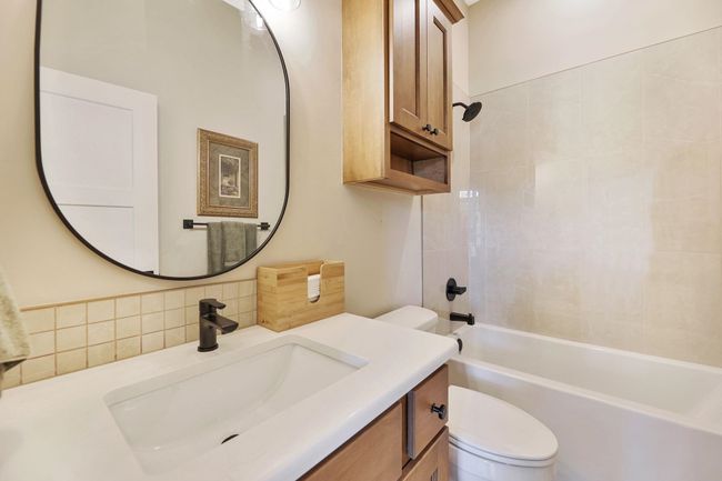 Full bathroom featuring decorative backsplash, tiled shower / bath, vanity, and toilet | Image 28